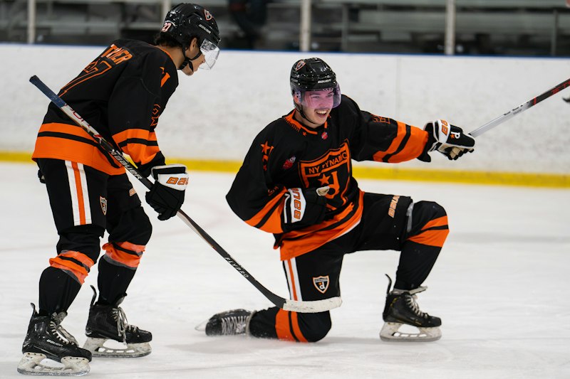 A NY Dynamo hockey player slides on one knee in celebration