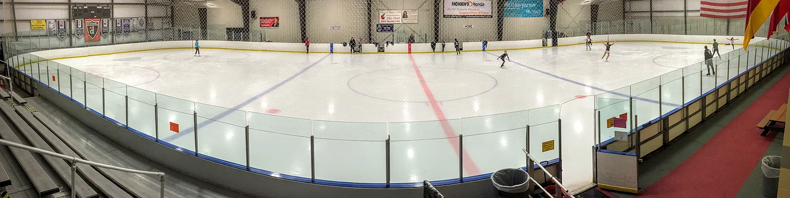 A wide view of an empty indoor ice rink.