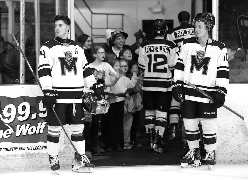 MAINEiacs players high-five young fans leaving the ice after a game